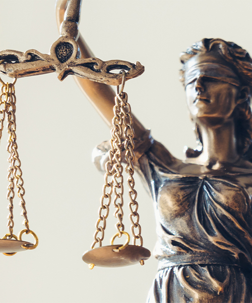 A detailed statue of Lady Justice, symbolizing impartiality and fairness in the legal system. She holds aloft the scales of justice, delicately balanced, reflecting the principles of truth and equity.