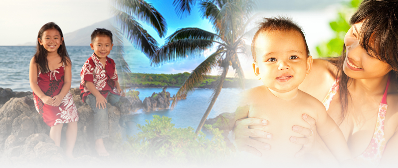 A family enjoying a tropical beach setting. Two children dressed in vibrant island attire sit on rocky outcrops, while a mother lovingly holds her smiling baby under the shade of palm trees.