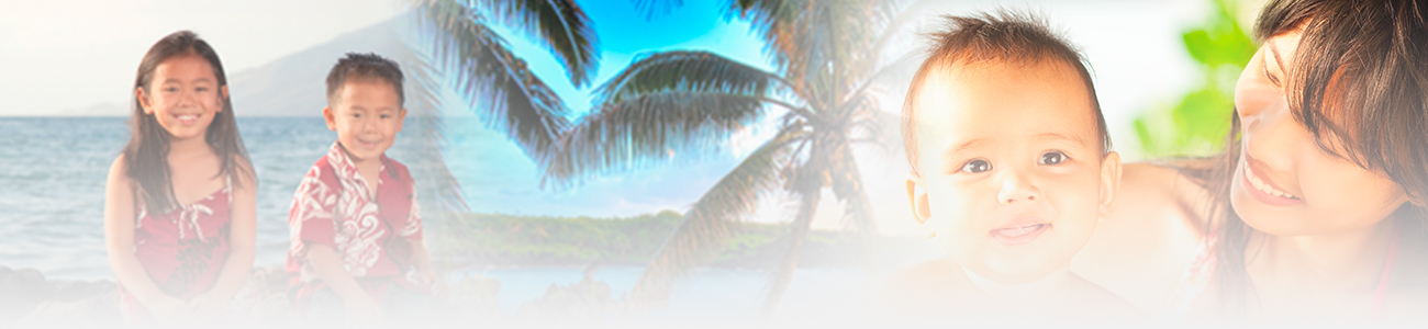 A family enjoying a tropical beach setting. Two children dressed in vibrant island attire sit on rocky outcrops, while a mother lovingly holds her smiling baby under the shade of palm trees.